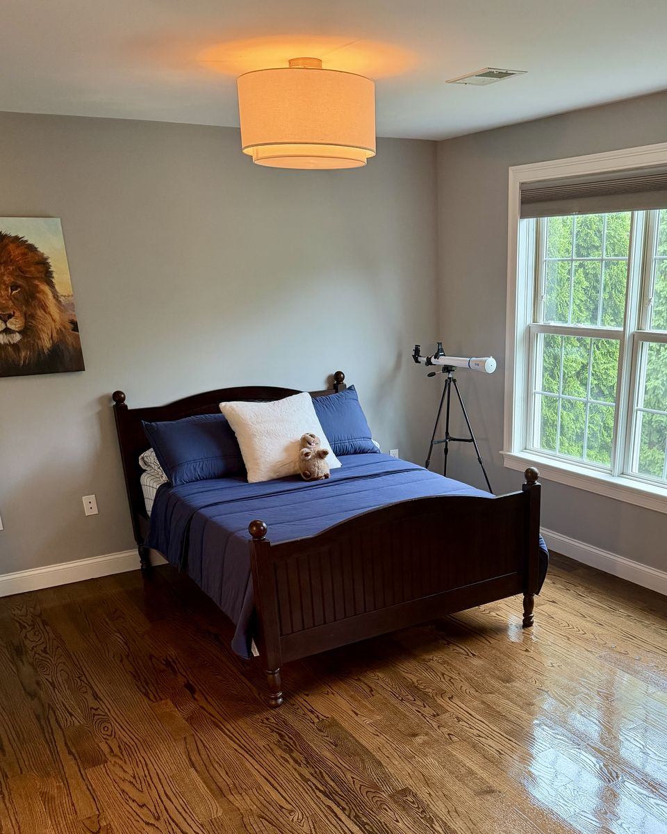 Tidy bedroom with a made bed and clean windows