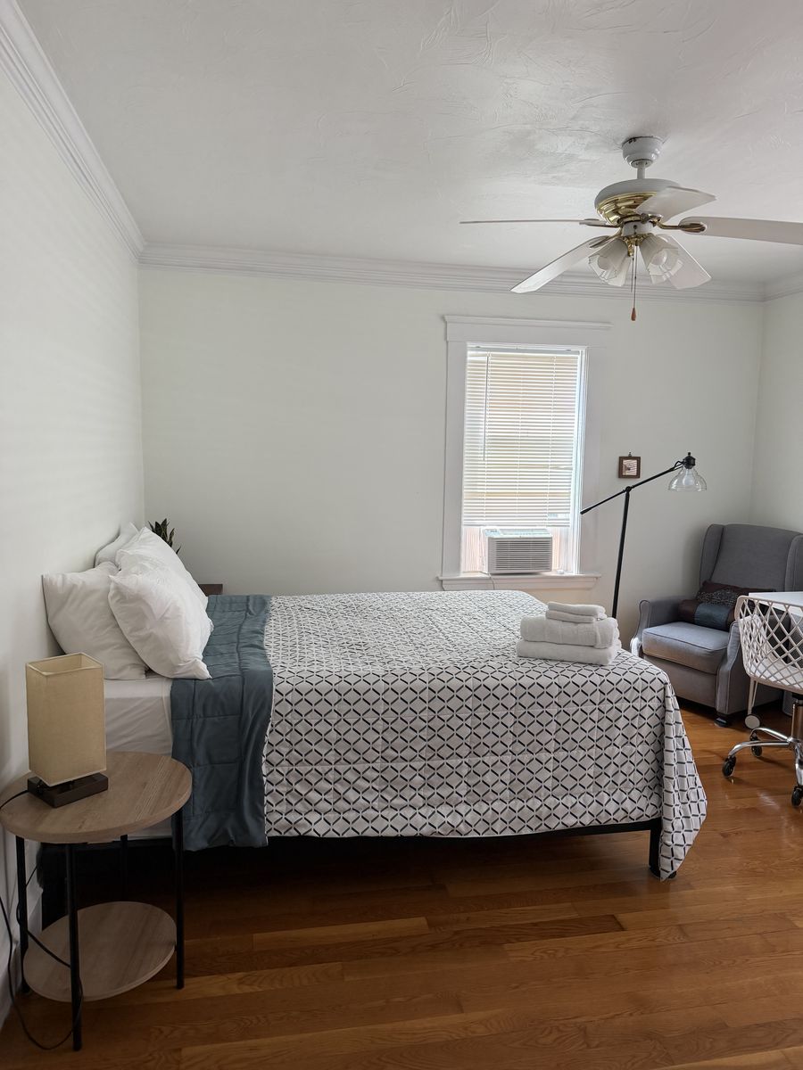 Bright bedroom with a neatly made bed and fresh towels